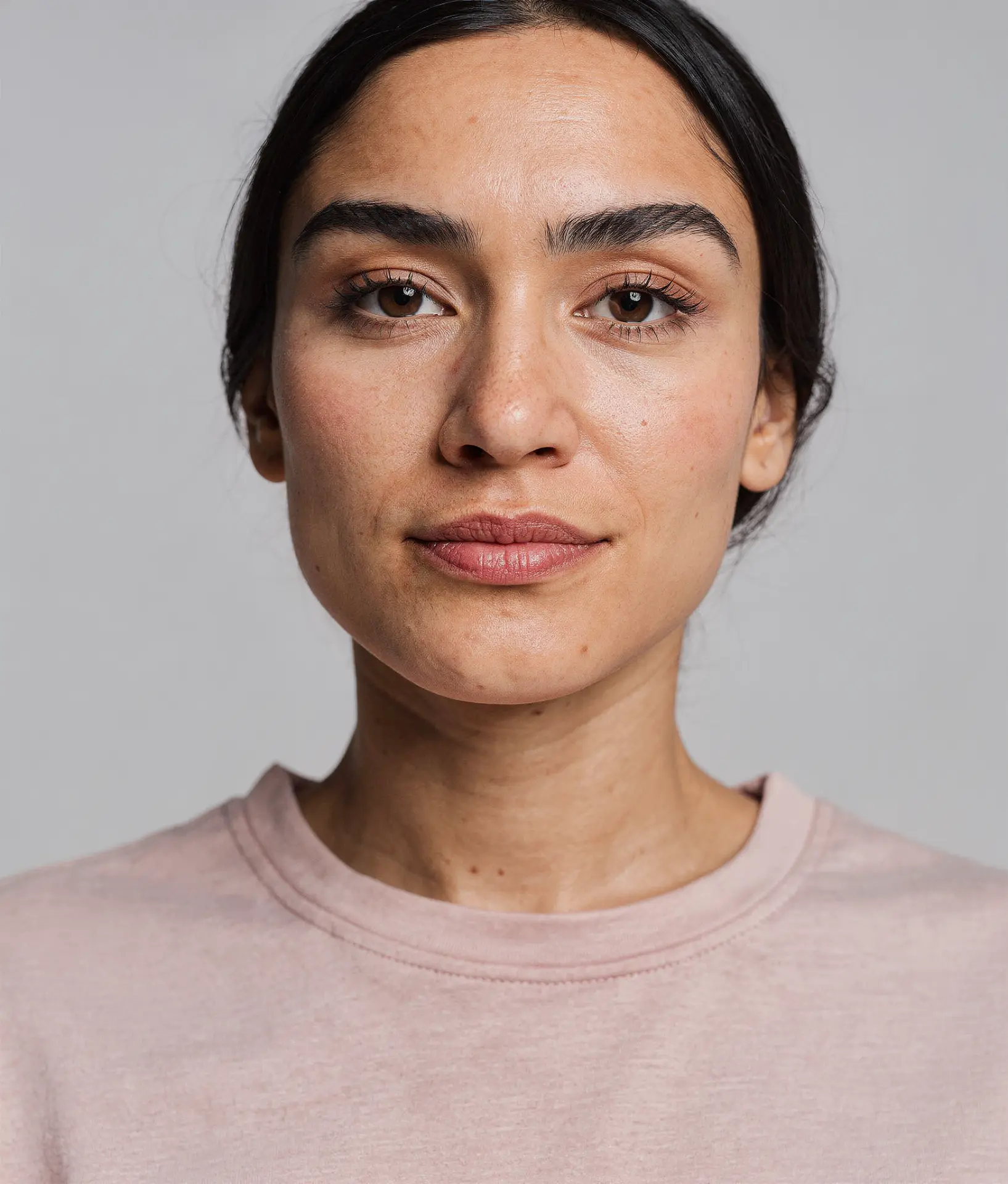 Close portrait of a woman in a soft pink t-shirt