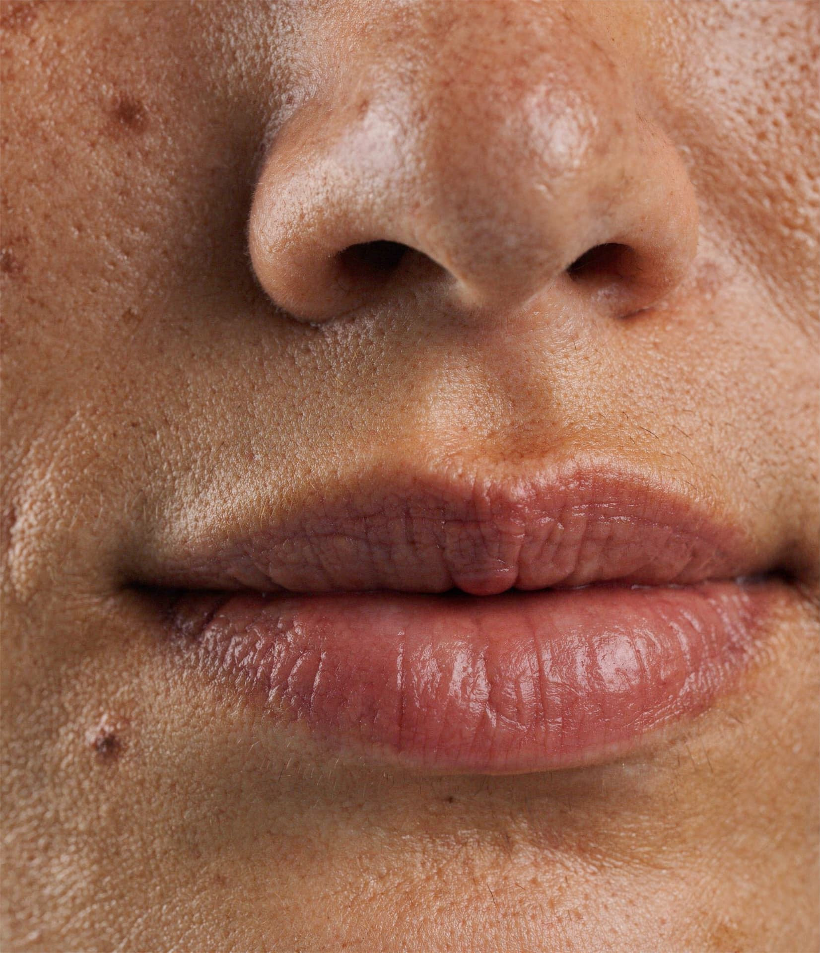 AI-generated macro view of a character's nose, mouth and skin texture with visible pores and small marks