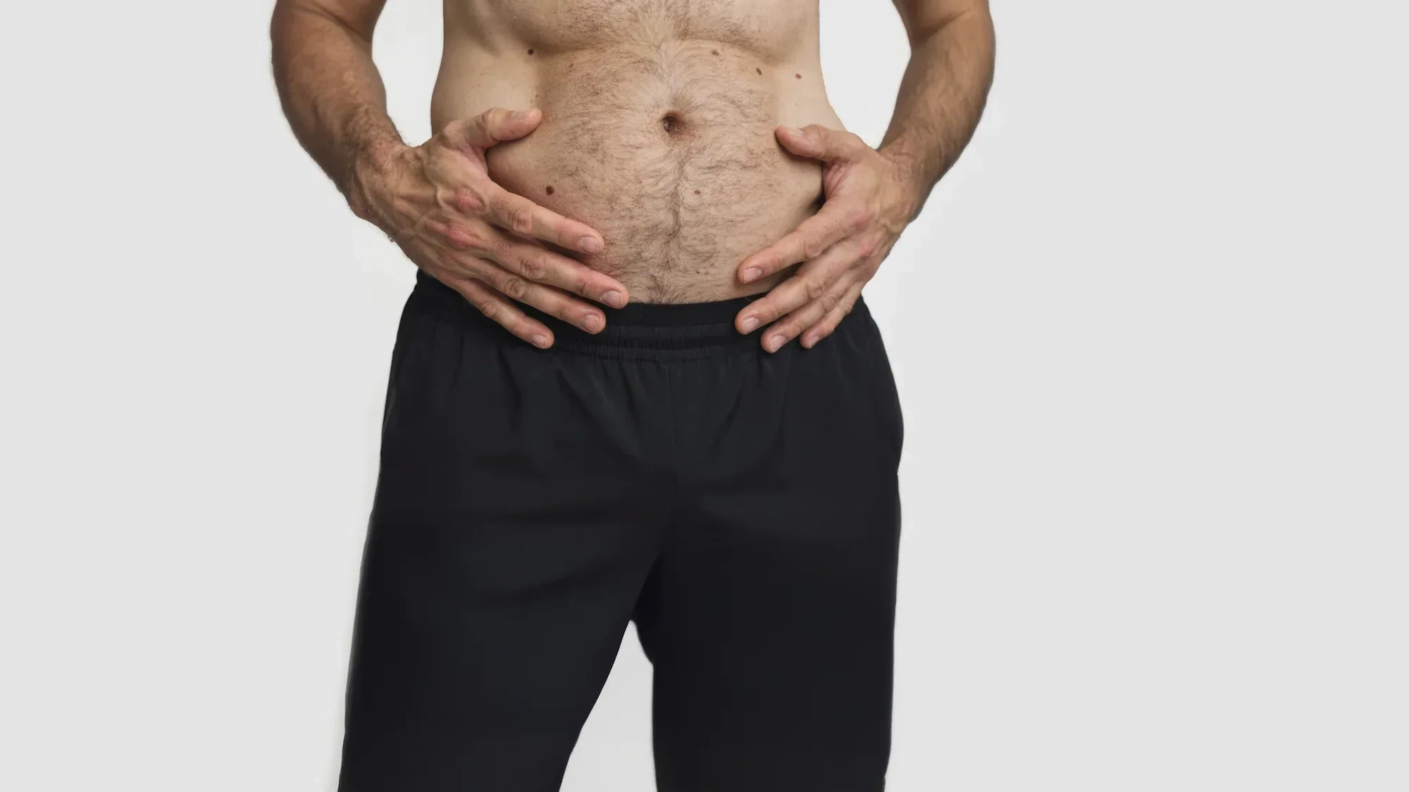AI-generated close view of both hands resting on a soft, hairy stomach above black trousers